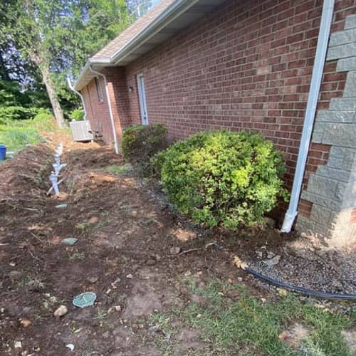 A partially buried drainage line showcasing the surface drains that take water away from the home's foundation