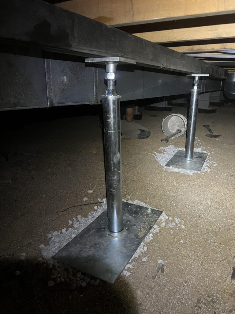 steel beams in a basement supported by push piers