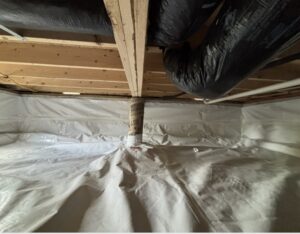 A crawl space with a plastic vapor barrier covering the floor and walls, exposed wooden beams overhead, and insulated ductwork running along the ceiling.